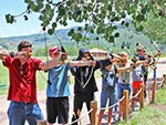 These youth all aim and prepare to fire off arrows at the same time at the Archery activity.