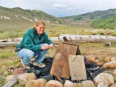 A Reid Ranch employee is ready to light the campfire at the Bunkhouse Fire Pit.