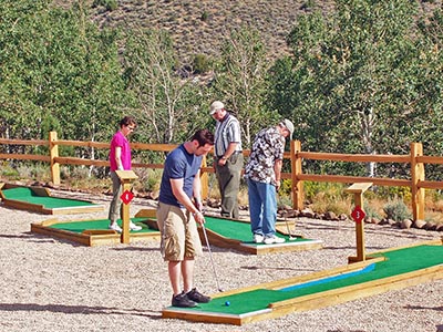 Two men preparing to put can be seen on holes three and four with others waiting their turn.