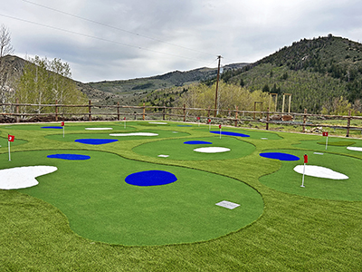 A view of the putting green with its rough areas and faux water and sand traps.