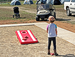 One young girl looks at her cornhole pitches. A fun game even for the very young.