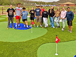 A youth group with leaders pose on the putting green before starting to play.