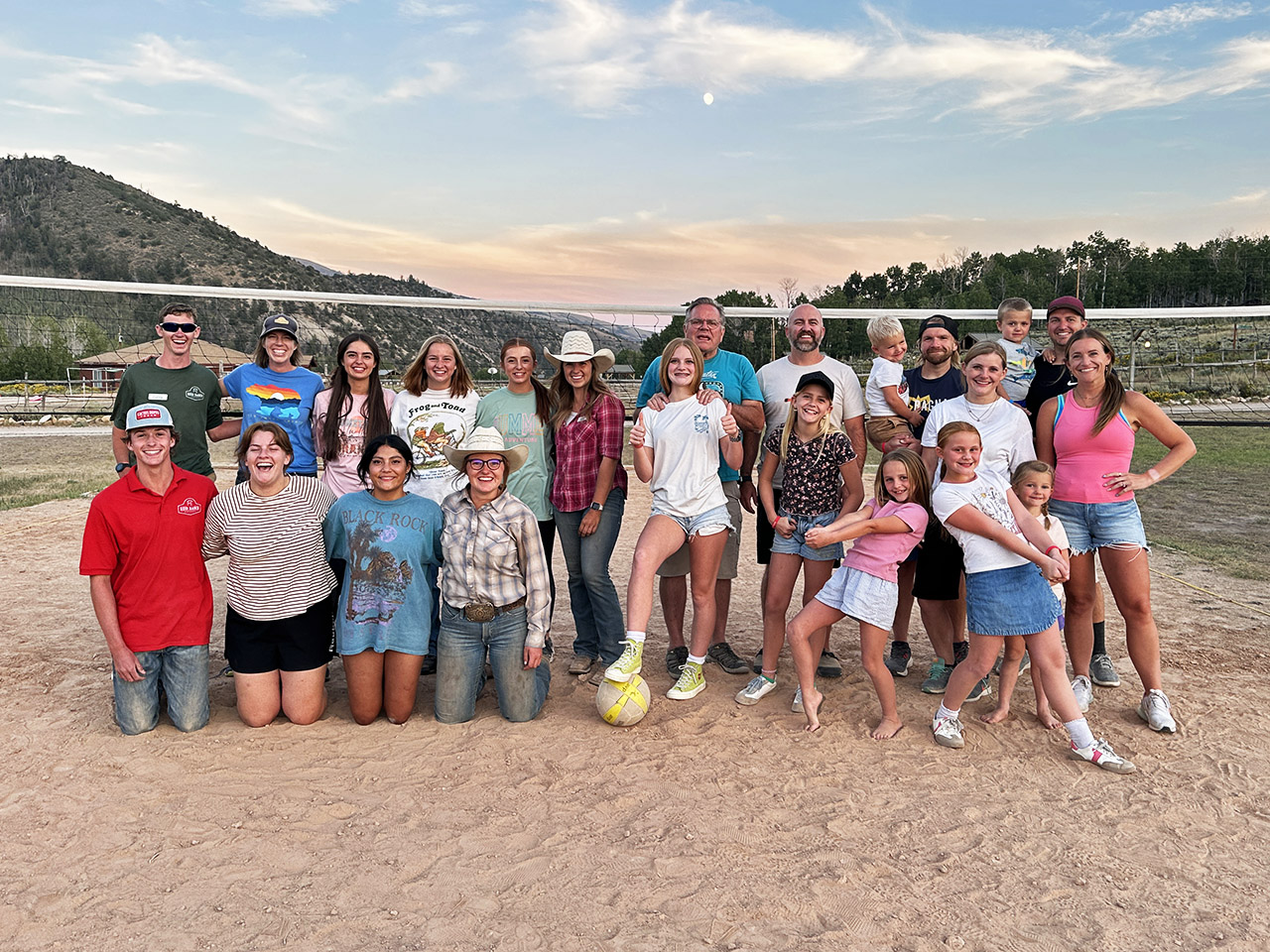 A family standing in front of the volleyball to show their love of the game for their family photo.